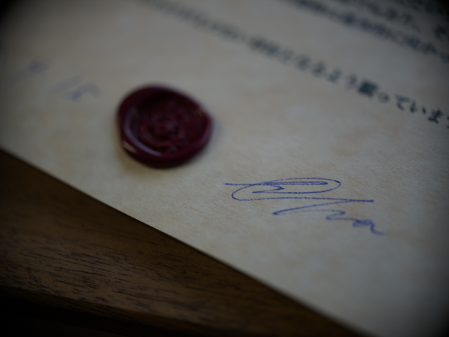 紋章状の写真（署名部分）