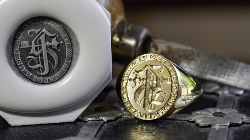 「千S+「鍵(+王冠)+モットー」※反転彫り 紋章のようなデザイン+模様やモチーフ